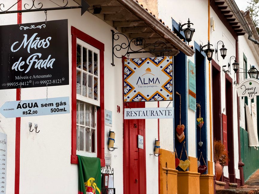 Fachadas coloridas com letreiros artísticos em uma rua pitoresca, evocando uma atmosfera vibrante.